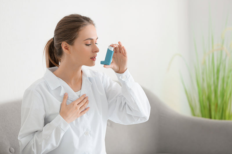 Frau benutzt ein Asthma-Spray