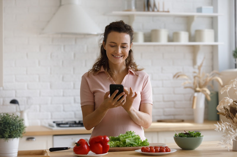 Frau plant Essen mit Smartphone