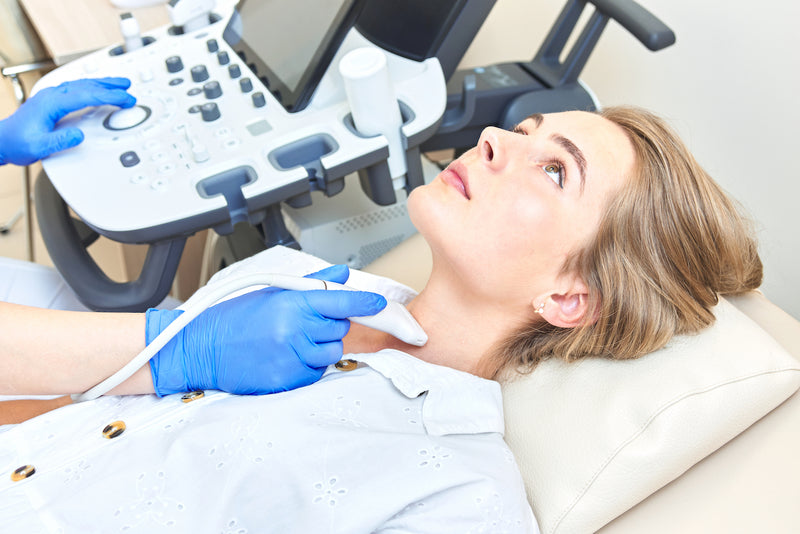 Schilddrüsensonografie: eine Frau wird per Ultraschall untersucht
