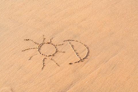 In den Sand geschrieben steht: Vitamin-D, dazu gezeichnet ist eine kleine Sonne