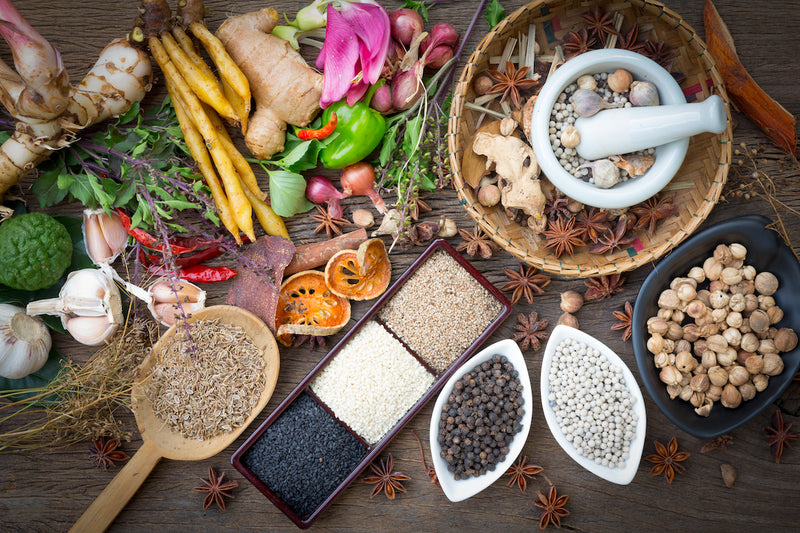 Ernährungsformen: Gewürze, Samen und Kerne auf Löffeln und in Schüsseln