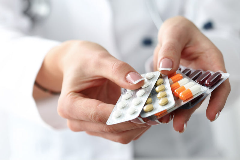 Schilddrüsenüberfunktion Hyperthyreose: Ärztin zeigt mehrere Blister mit Tabletten