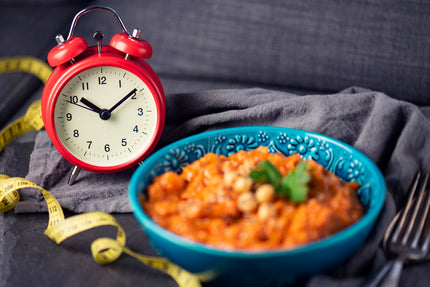 Gesund abnehmen ohne Jojo-Effekt: Ein Teller mit Essen und ein Wecker