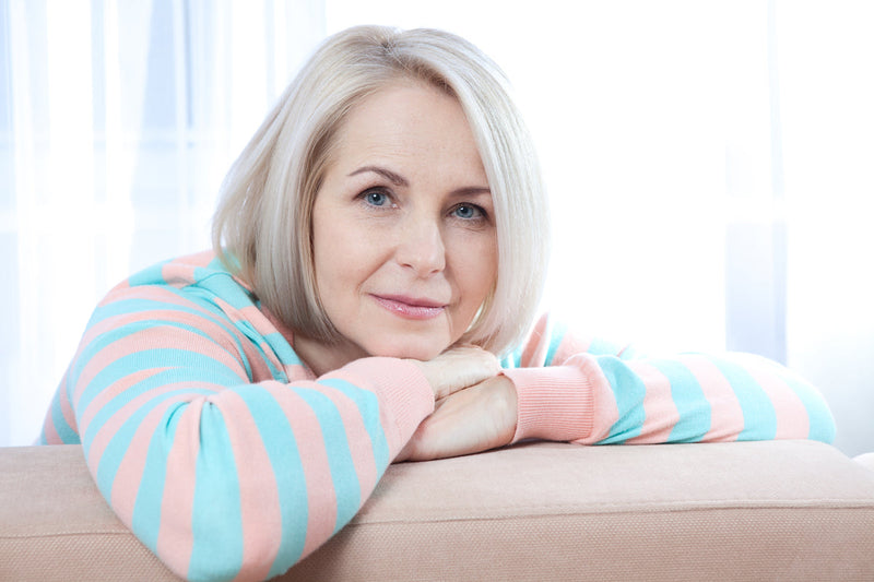 Frau sitzt entspannt auf dem Sofa