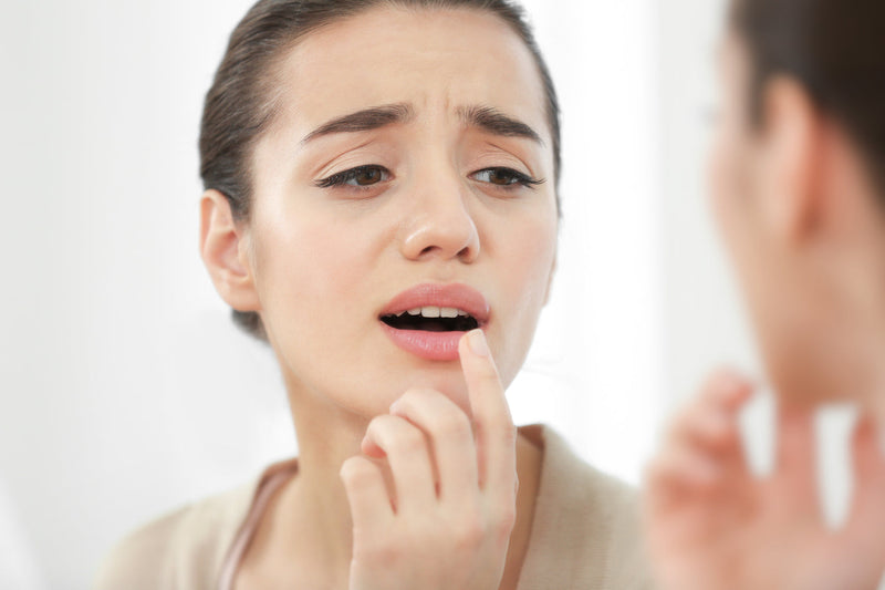 Frau begutachtet ihre Lippe im Spiegel
