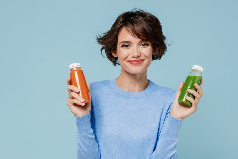 Frau hält eine Flasche mit Saft in jeder Hand