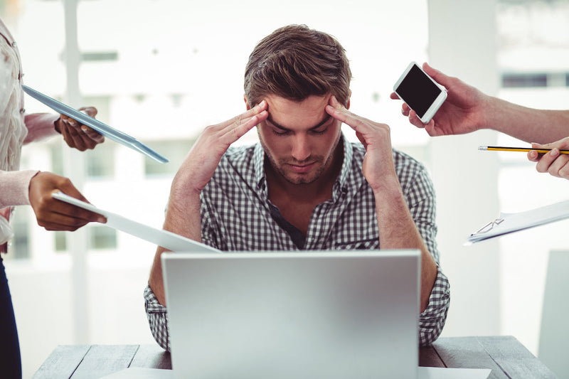 Mann sitzt vor dem Laptop und hat Stress