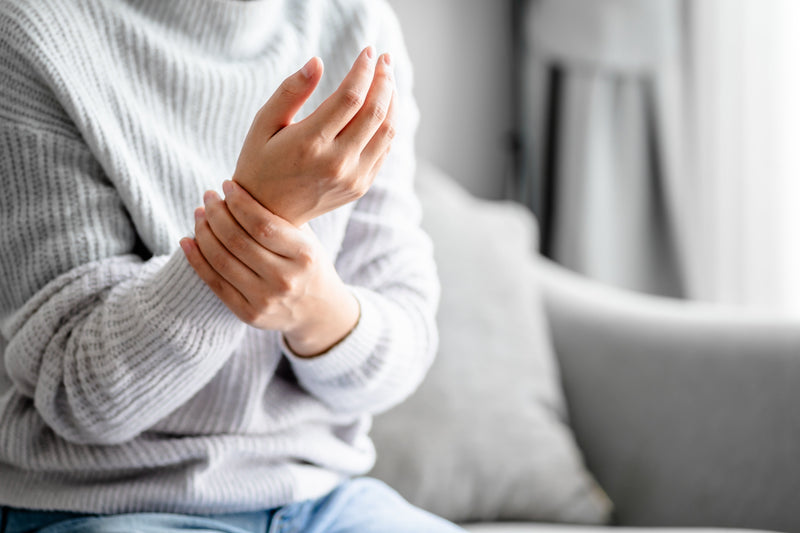 Neurologische Beschwerden: Frau hält sich die Hand