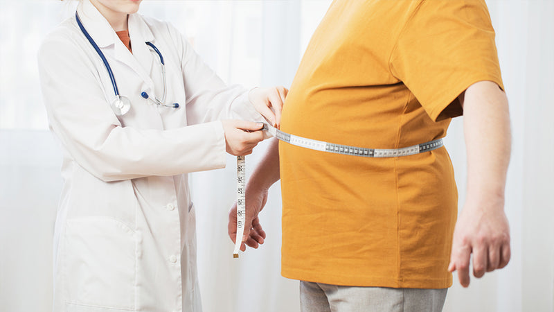 Fettleber Symptome Ursachen: Ärztin misst Bauchumfang eines Patienten