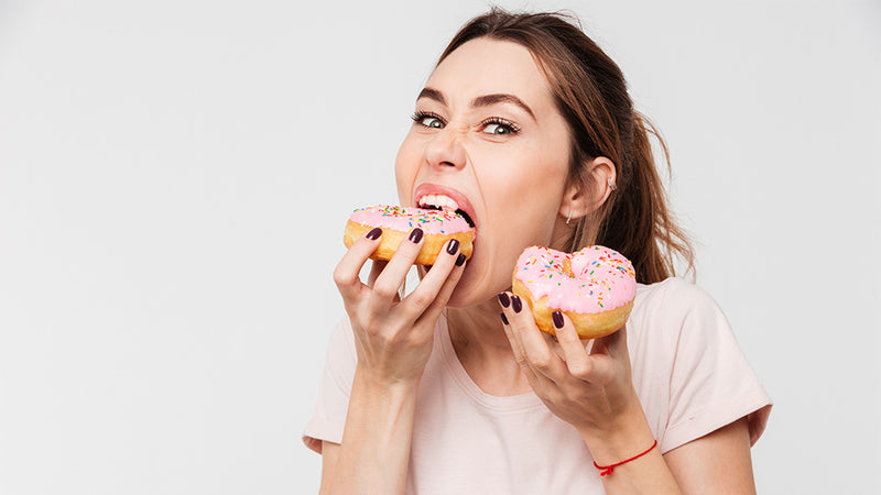 Frau beißt hungrig in einen Donut