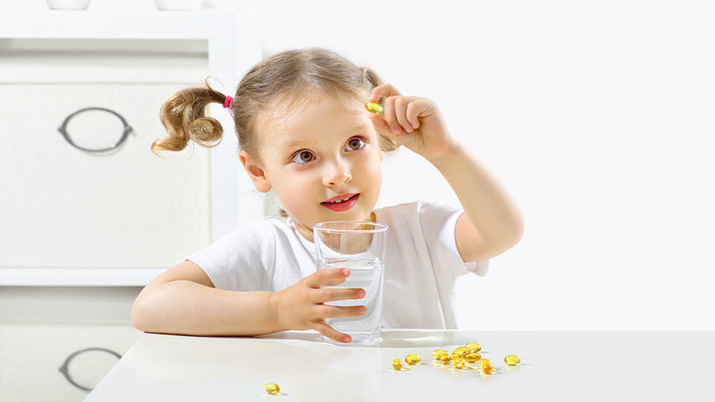 Mädchen spielt mit Nahrungsergänzungsmittel-Kapseln