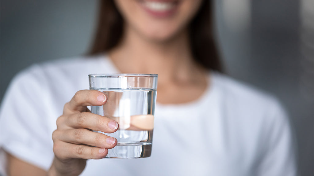 Frau hält ein Glas Wasser