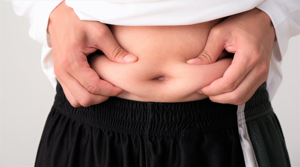 Person greift mit den Händen an ihren Bauch