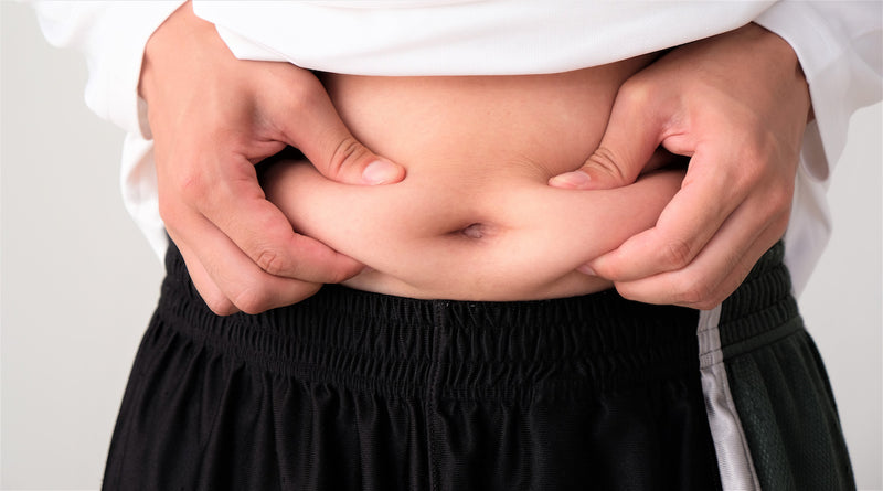 Person greift sich in Haut am Bauch