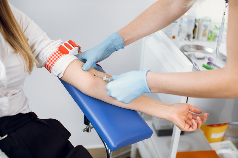 Blutabnahme: Einer jungen Frau wird Blut in der Praxis abgenommen