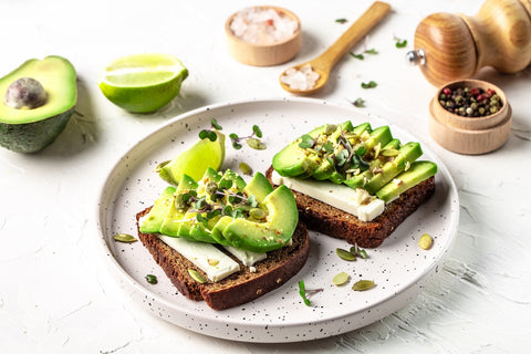 Gesunde Snacks für abends: Zwei Scheiben Brot mit Avocado auf einem Teller