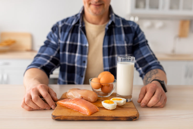 Pflanzliches oder tierisches Protein: Mann sitzt vor Teller mit tierischen Lebensmitteln