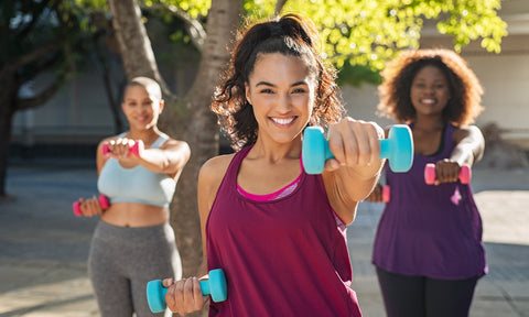 Drei Frauen machen fröhlich Sport zusammen