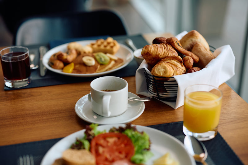 Abnehmen im Urlaub? Auf diesem Tisch stehen ein Frühstücksteller in einem Hotel mit einem Korb voller Croissants