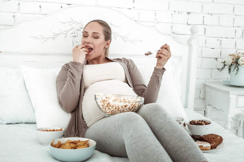 Schwangere Frau isst Snacks