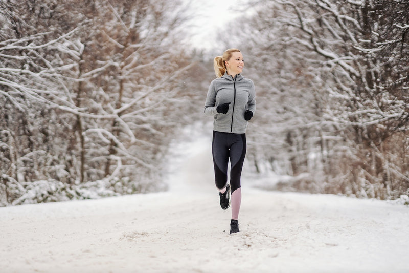 Frau joggt durch eine Winterlandschaft
