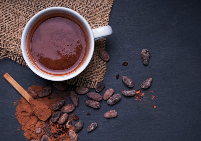 Gesunde Snacks für abends: Kakao in Tasse und Kakaobohnen