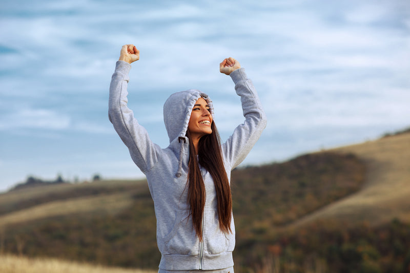 Antioxidantien: Frau streckt glücklich beide Arme in die Luft
