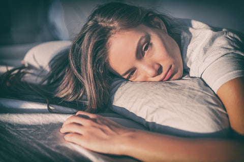 Frau liegt müde im Bett