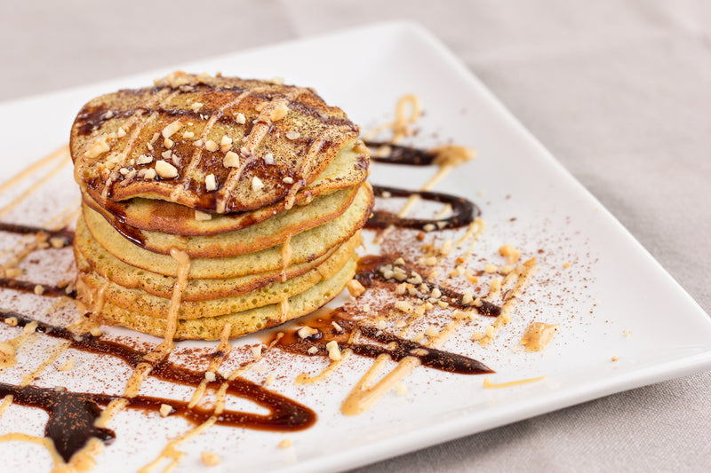 Protein Pancake Rezepte: Teller mit Pancakes mit Erdnussbutter und Erdnusssplittern
