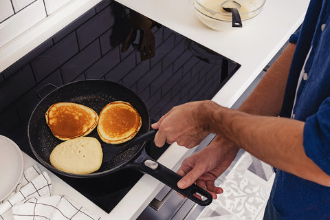 Person backt Pancakes in einer Pfanne