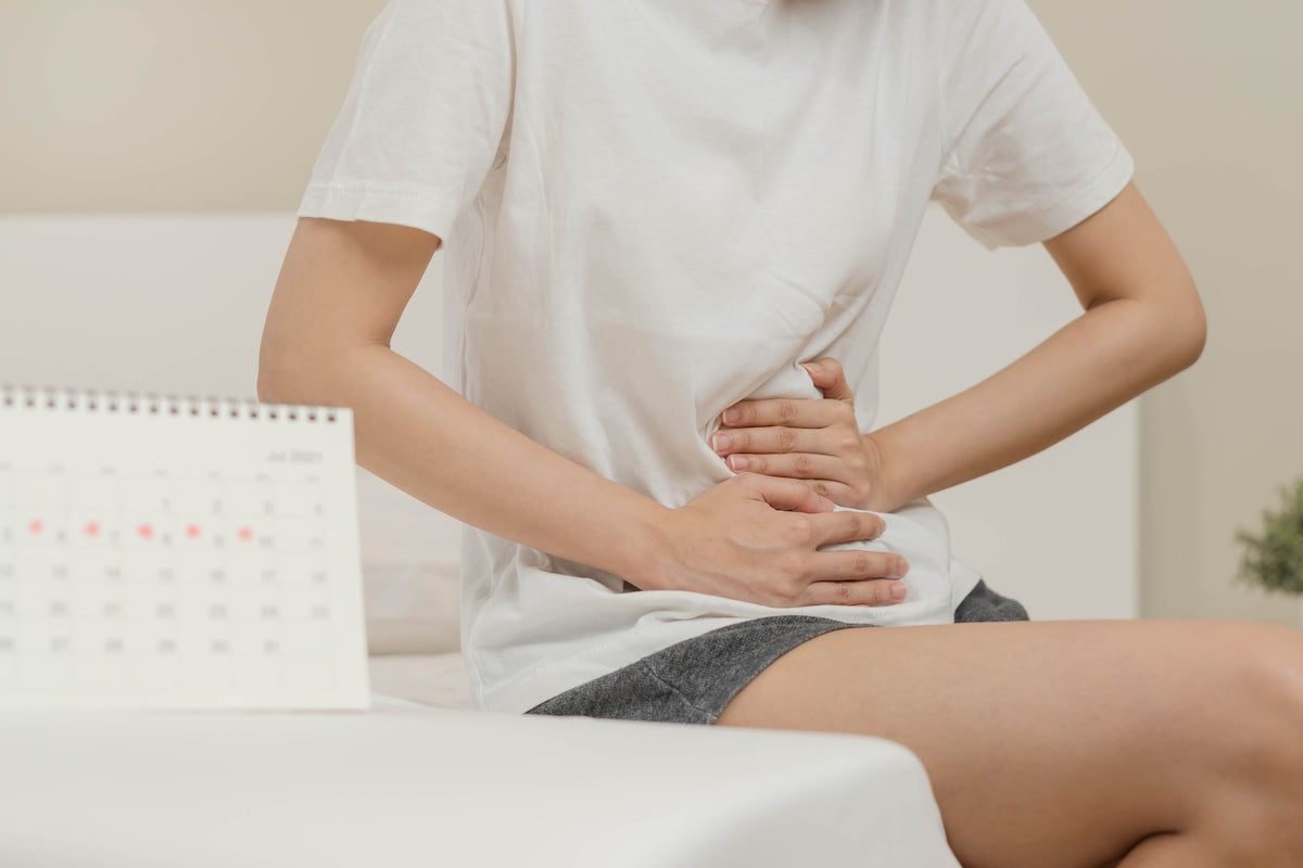 Frau hält sich den Unterleib vor Schmerzen