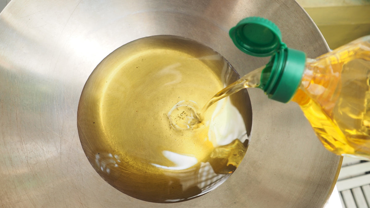 Öl wird in eine Pfanne gegossen