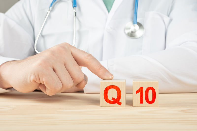 Arzt tippt auf Holzklötze mit Aufschrift Q10