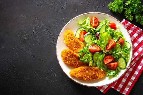 Ein Salat mit drei panierten Fischfilets dazu