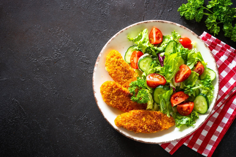 Ein Salat mit drei panierten Fischfilets dazu