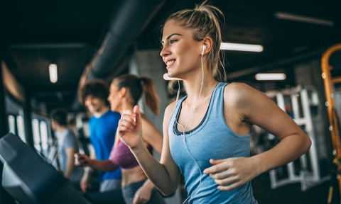 Was tun gegen Kopfschmerzen - Hausmittel: Frau trainiert auf dem Laufband im Fitnessstudio