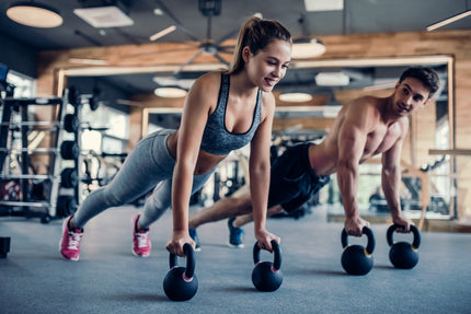 Muskeln: Frau und Mann trainieren mit Kettlebells