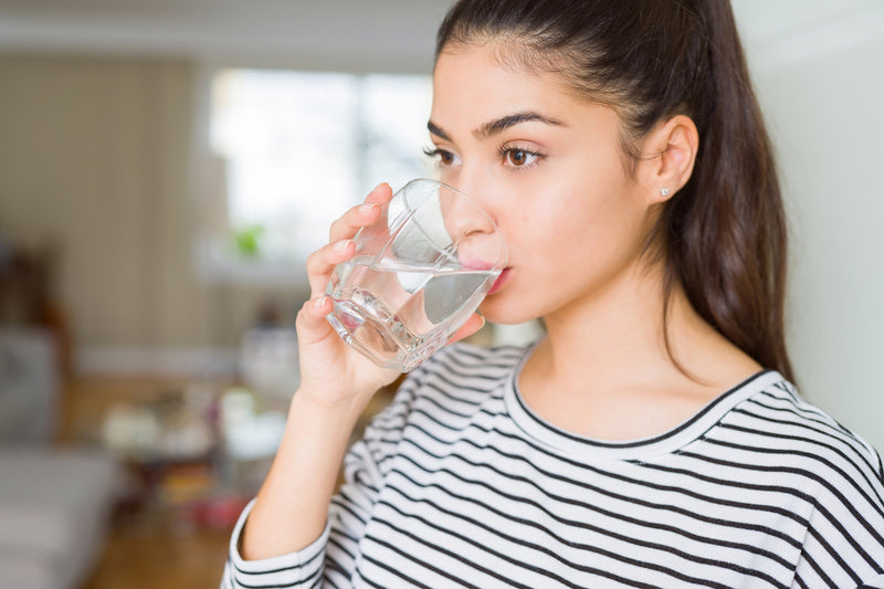 Immunsystem stärken: Frau trinkt ein Glas Wasser