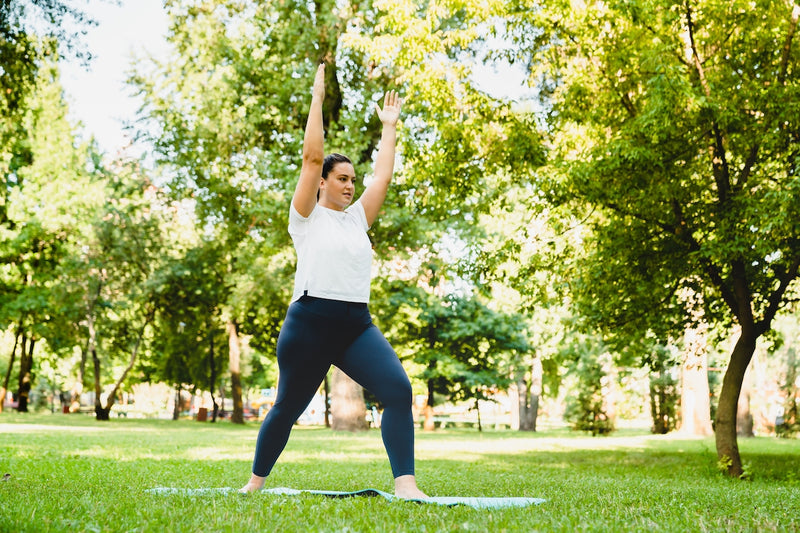 Frau macht Yoga-Übungen draußen