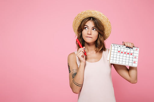 Frau plant Zyklus mit Kalender