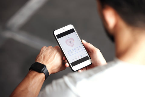 Fitness-Tracker Gesundheit: Mann verbindet seine Fitnessuhr mit dem Handy