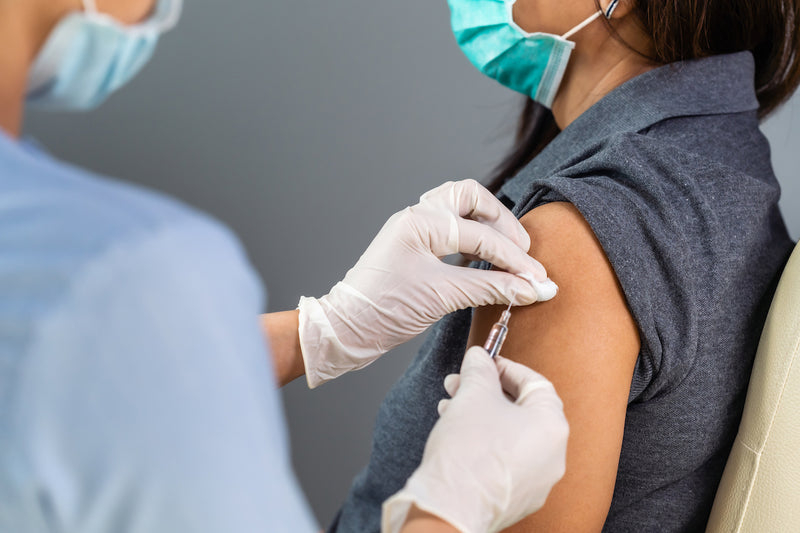 Frau bekommt eine Impfung in den Arm