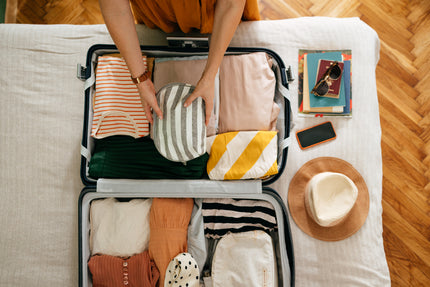 Sommerurlaub-Essentials: Person packt einen Koffer