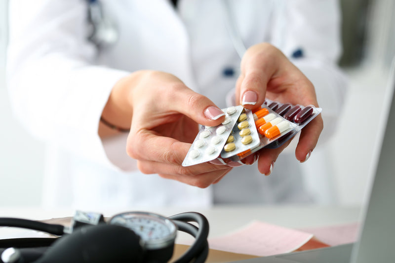 Ärztin zeigt Blister mit Medikamenten