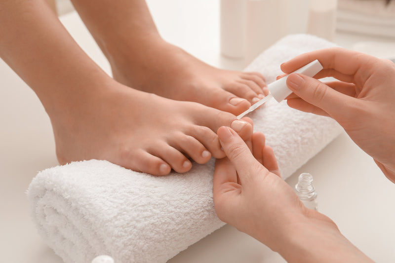 Nagelpilz bekämpfen: Nagellack wird auf Fußnägel aufgetragen