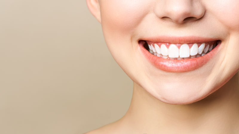 Frau zeigt Zähne beim Lächeln