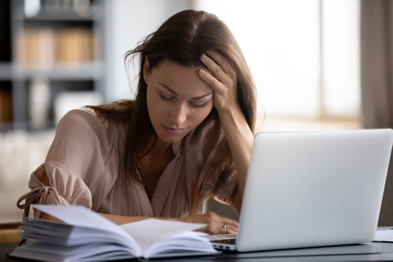 Frau müde Arbeit Schreibtisch Bücher Laptop 