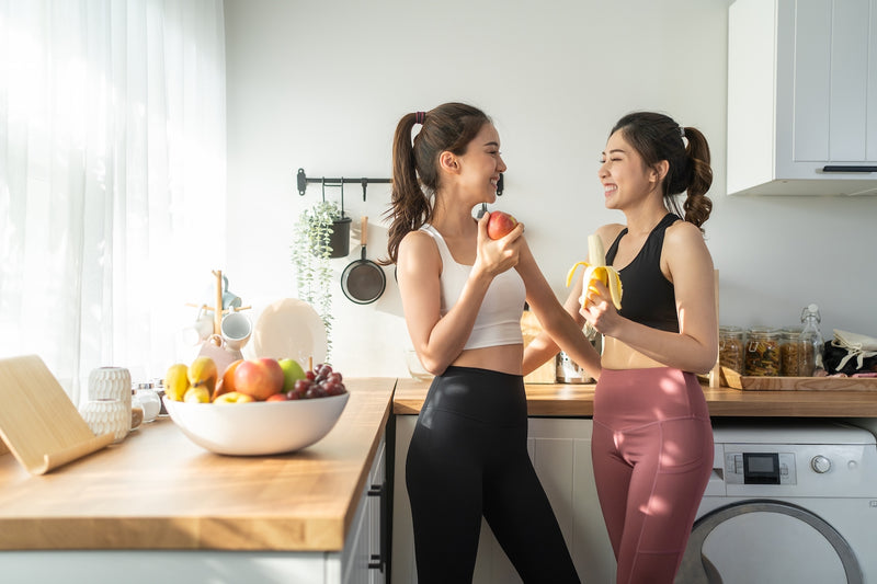 Zwei Frauen essen in der Küche Obst