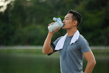 Eiweiß-Mythen: Mann im Sportoutfit trinkt einen Proteinshake