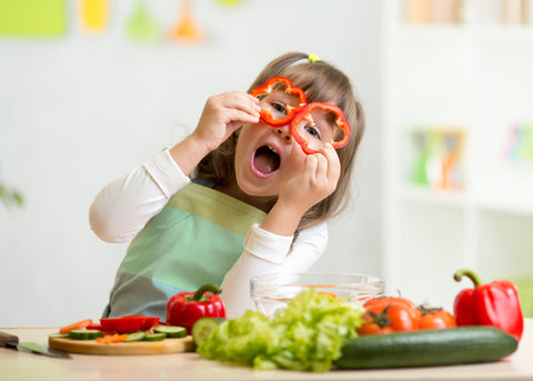 Kind hält sich Paprika vor die Augen